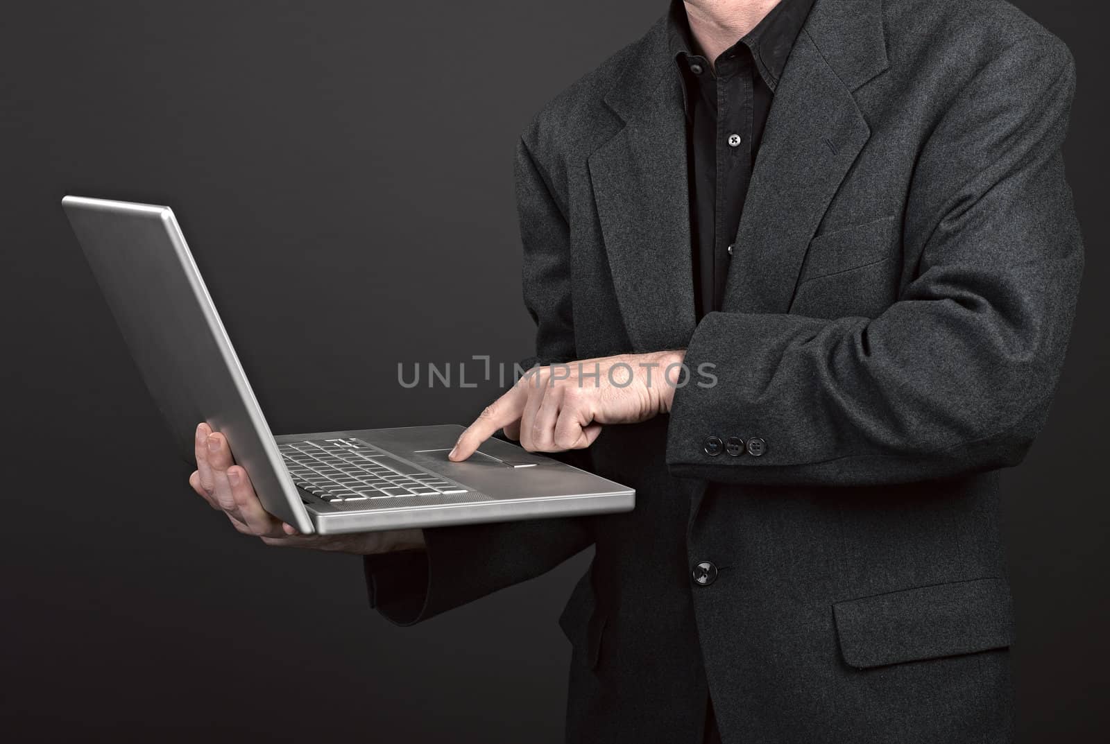 Businessman holding his laptop by pbombaert