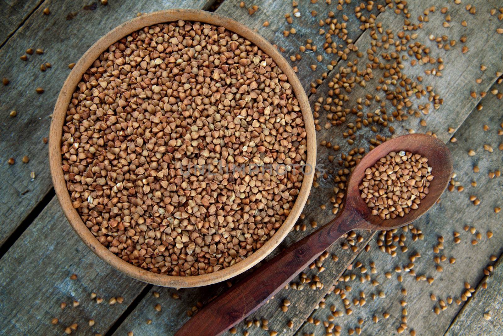 Crude buckwheat in te wooden plate on te table