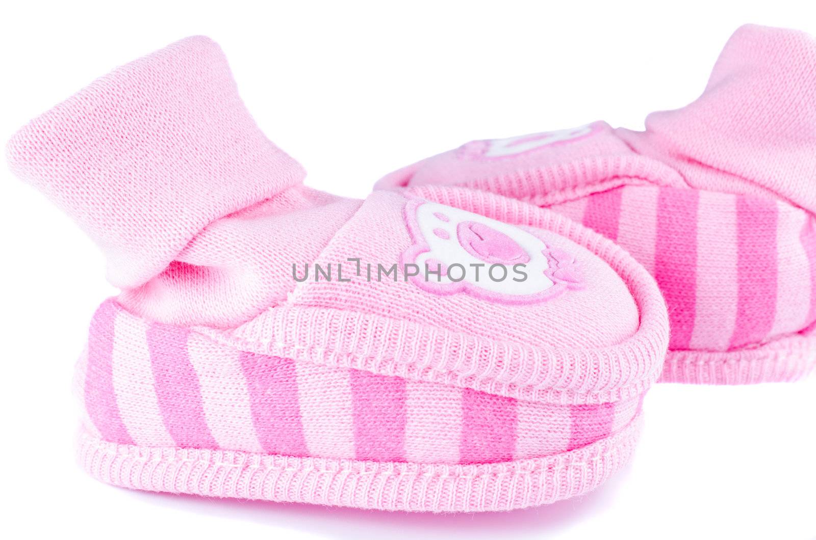 Pink woven baby shoes on white by Nanisimova