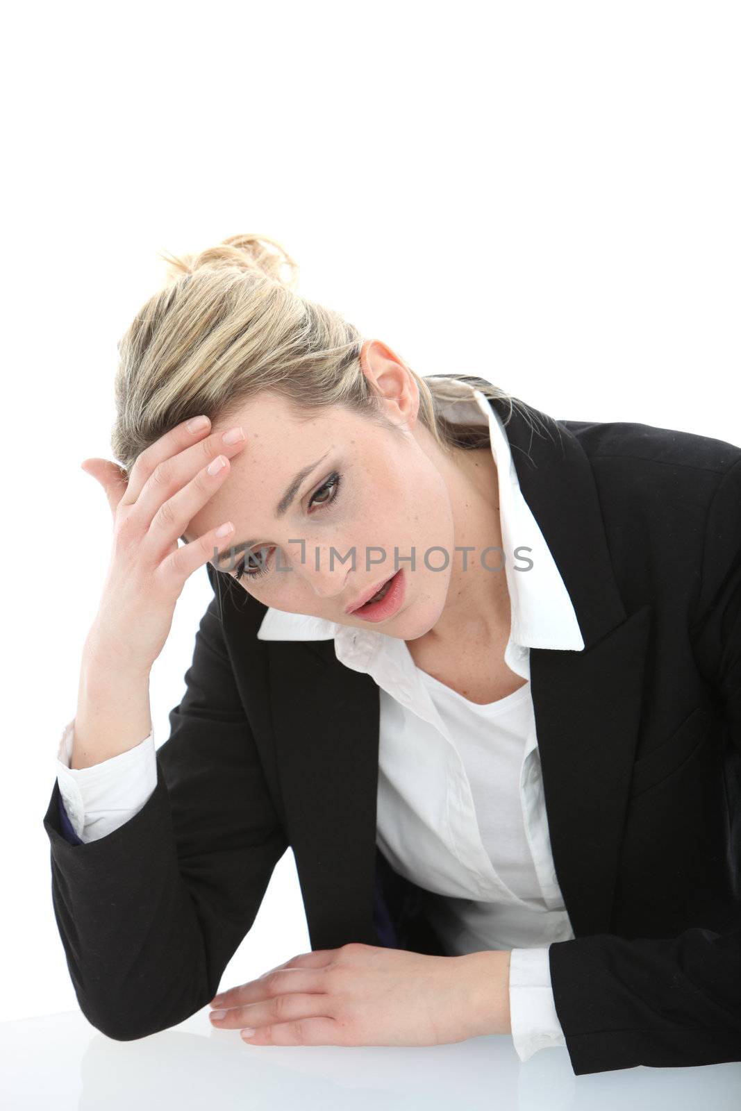Distraught young businesswoman with an apprehensive expression sitting with her forehead in her hand