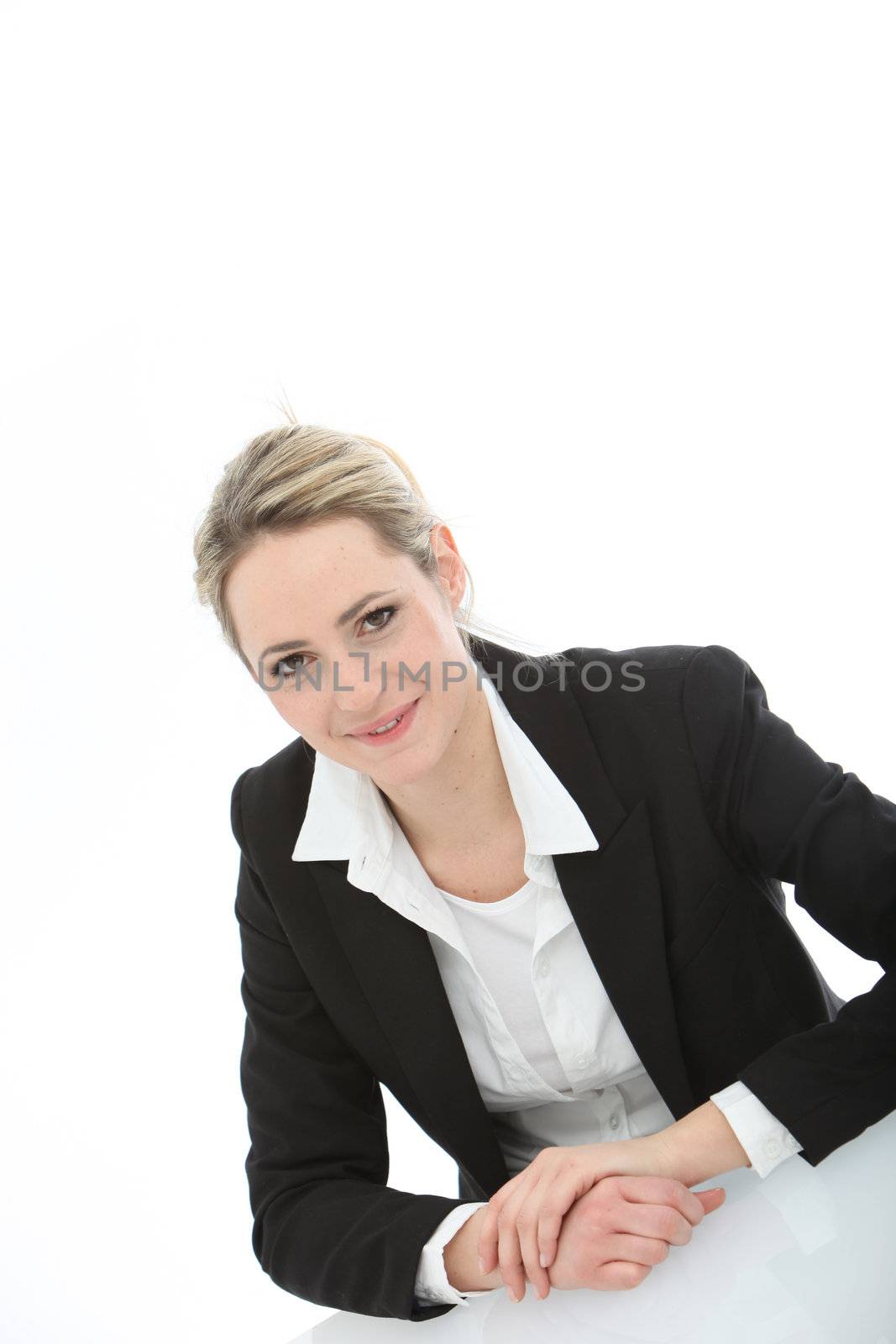 Young, smiling business woman sitting at the table on white background