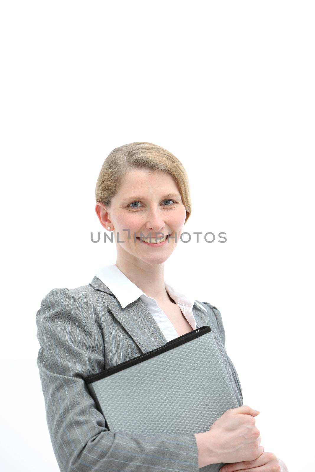 Smiling friendly young blonde female office worker or businesswoman holding a folio file in a stylish grey jacket