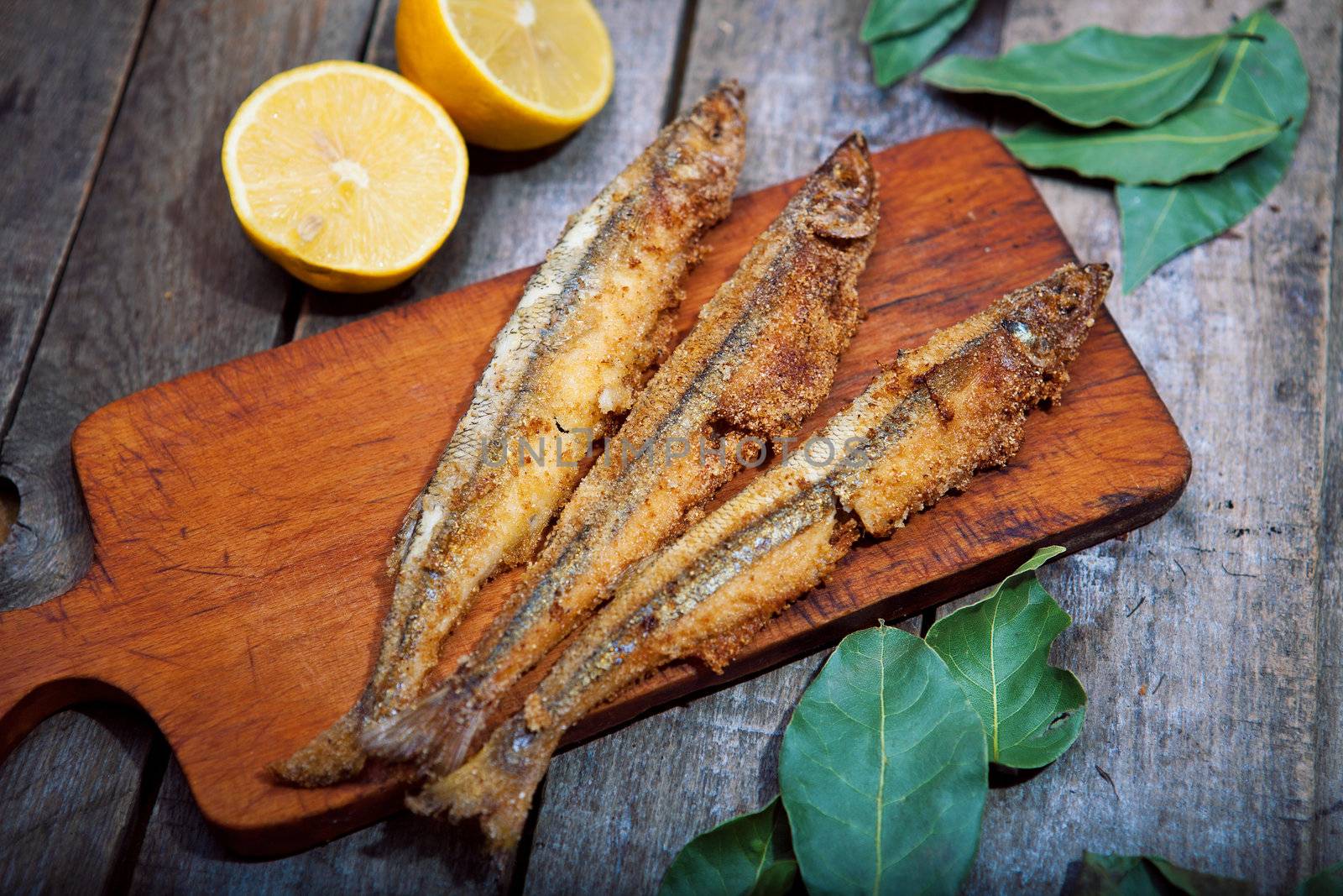 Baked fish with lemon on a wooden table