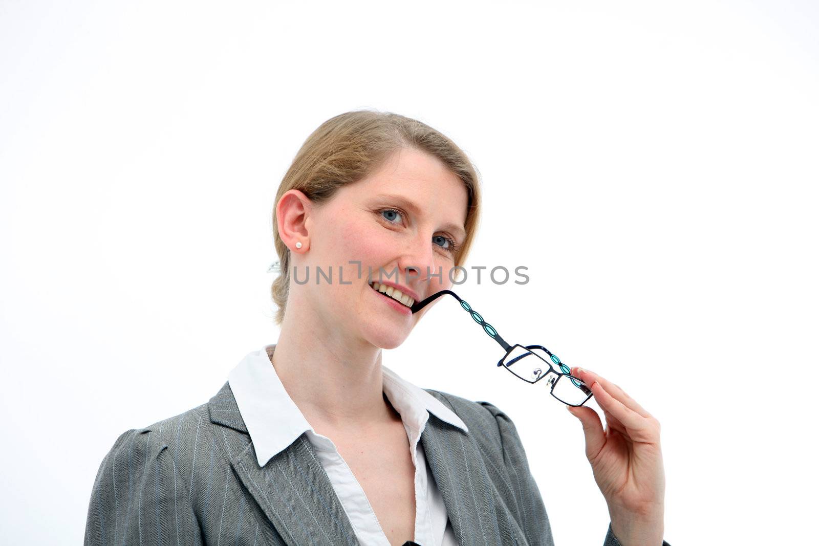 Introspective woman thinking and watching with her head tilted to one side and her glasses to her mouth