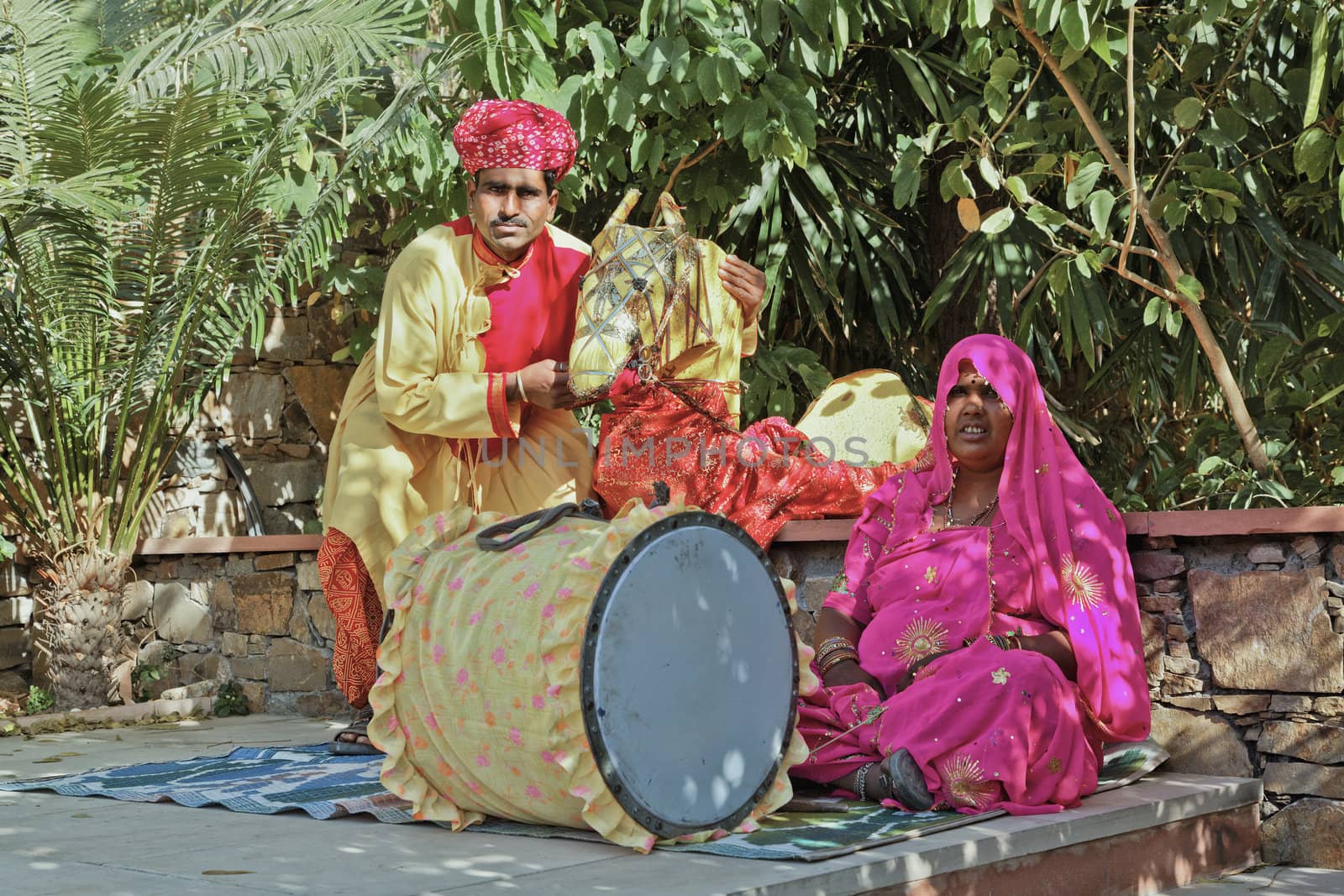 Landscape portrait of a Colorful couple traveling puppeteer musician resting in the shade before a performance