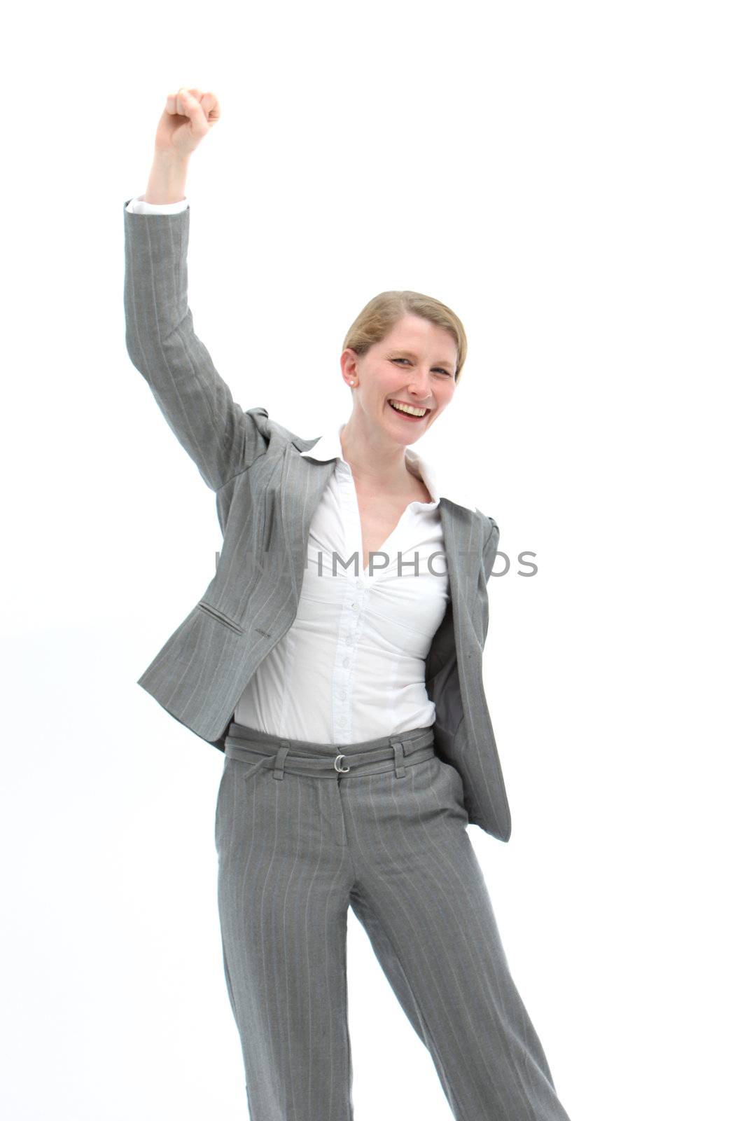 Motivated businesswoman in a stylish slacksuit raising her fist in the air and cheering