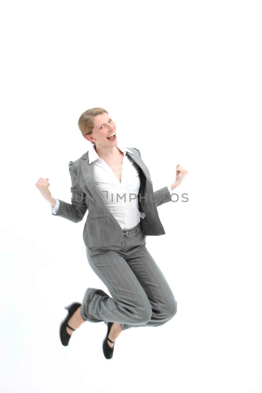 Successful woman jumping for joy with both feet raised and her fists clenched in happiness isolated on white