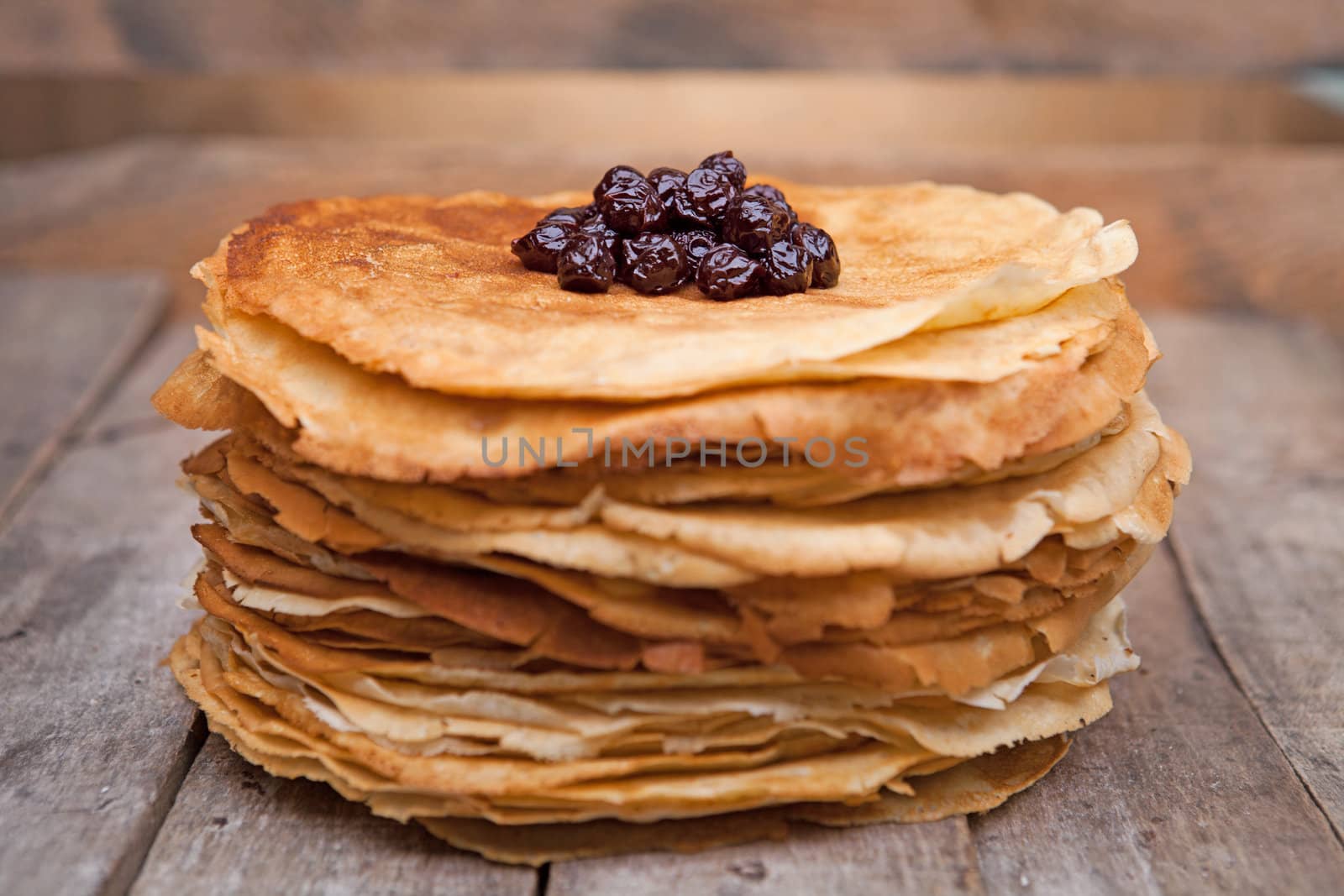 Crepes on the wooden table with cherry
