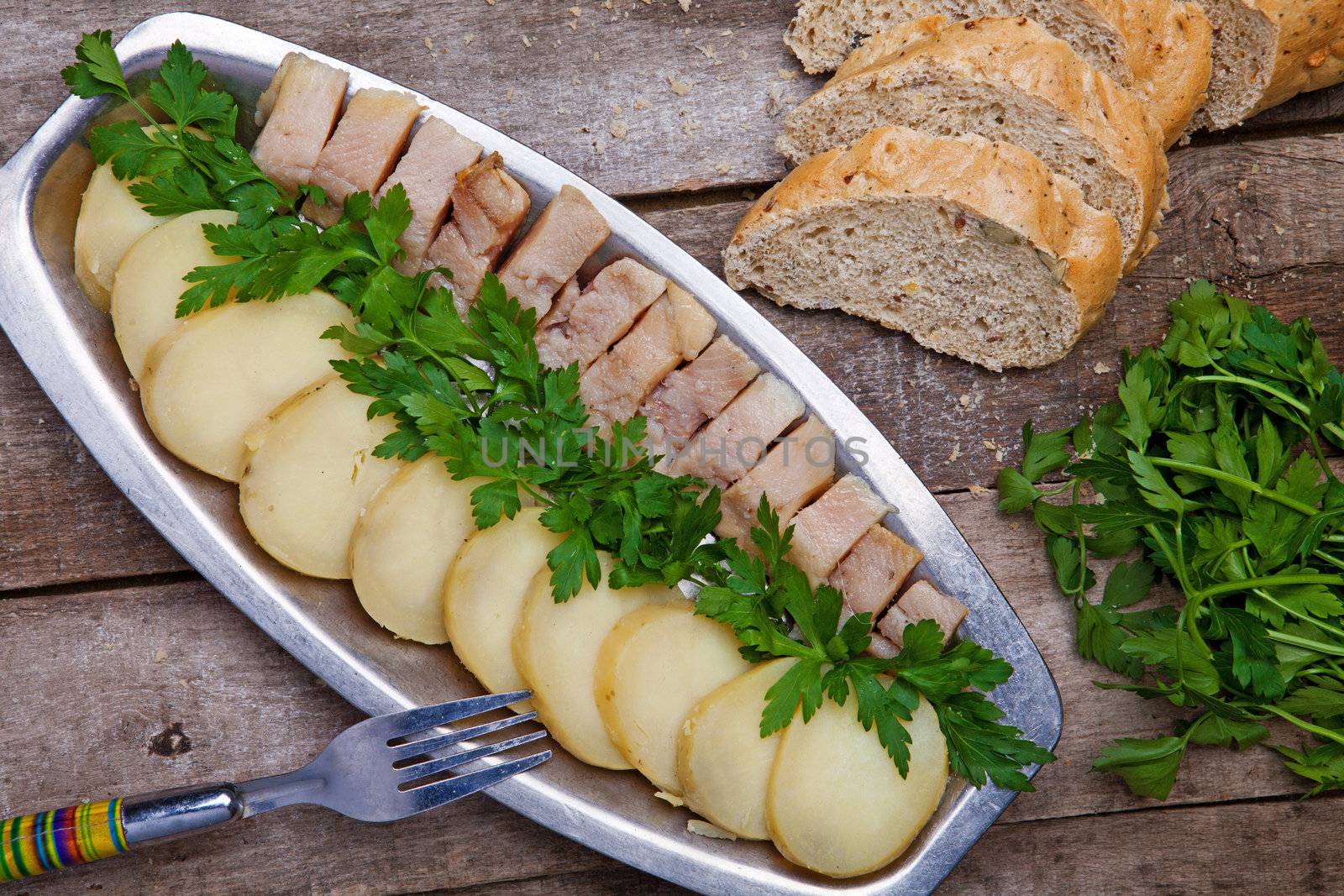 Herring with potato and  parsley on a wooden table