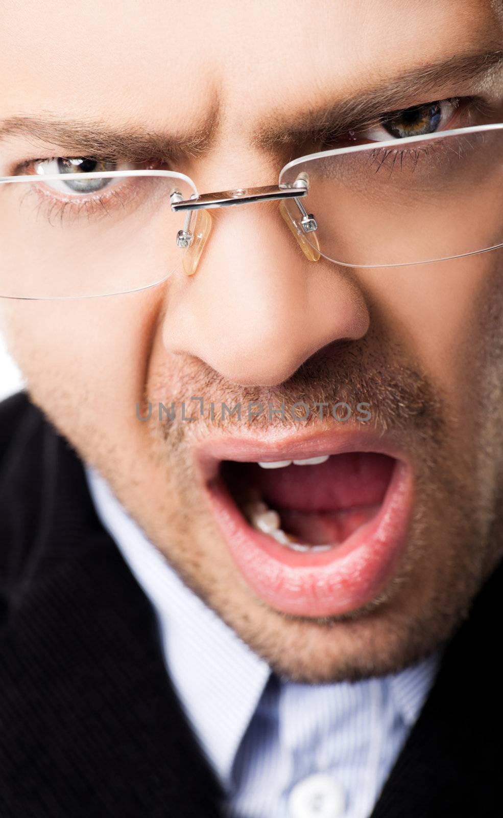Close-up of angry young man with glasses and open mouth