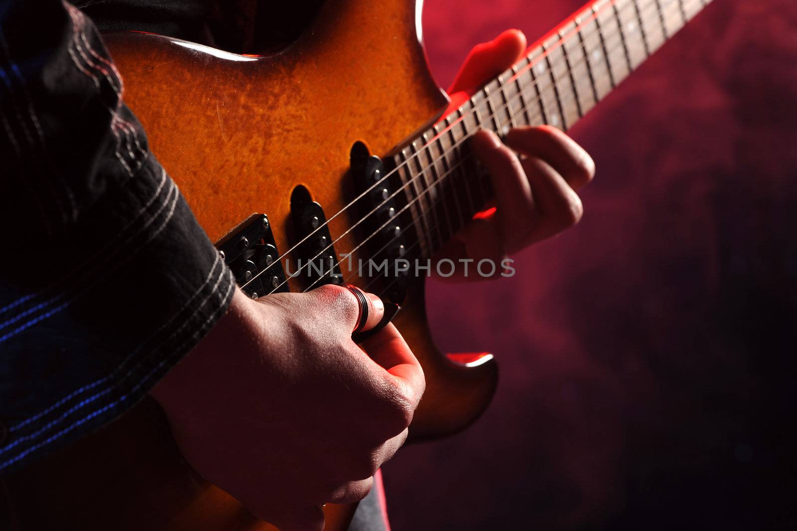 close up of hands playing an electric guitar