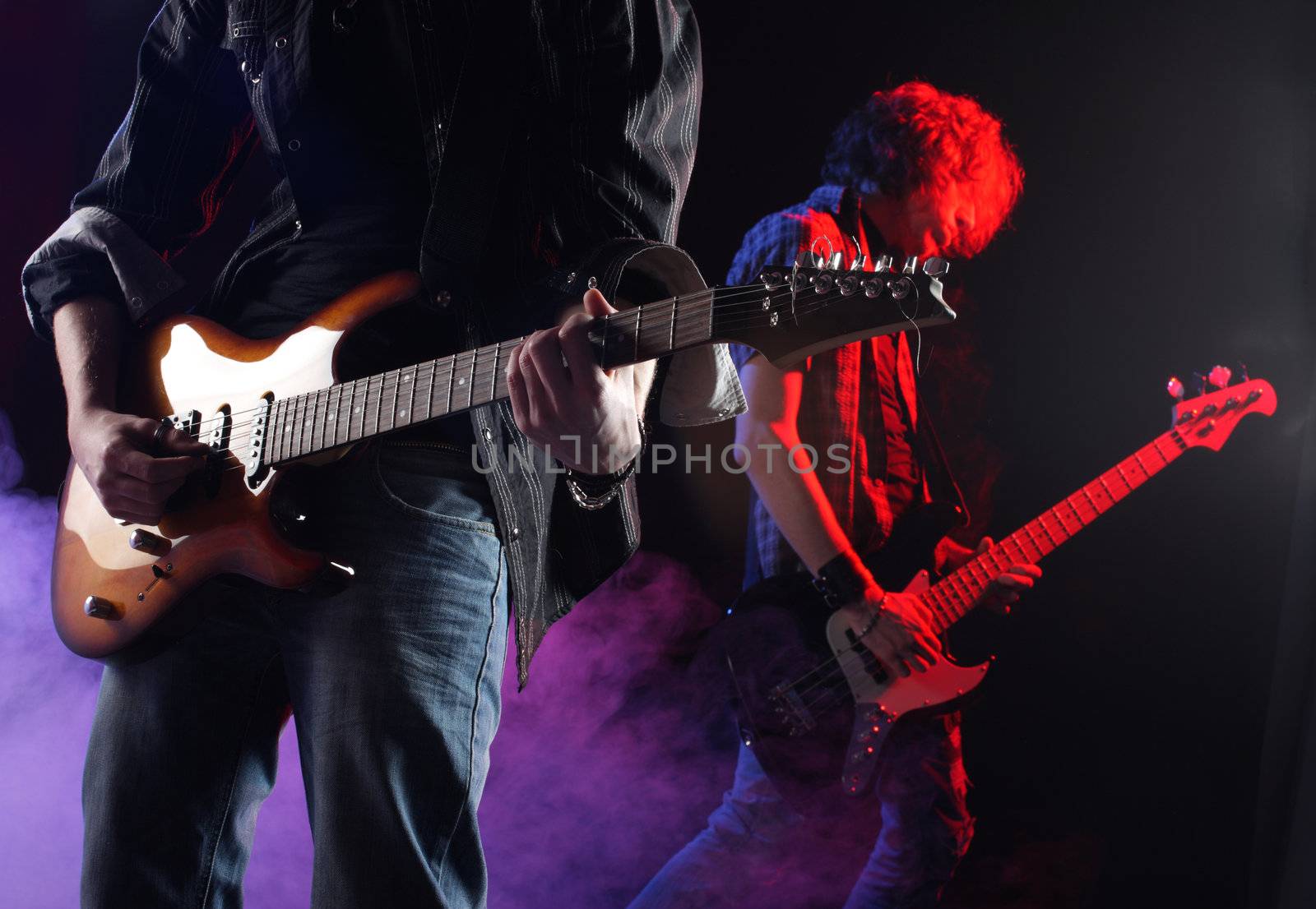 rock musicians playing at a live concert by stokkete