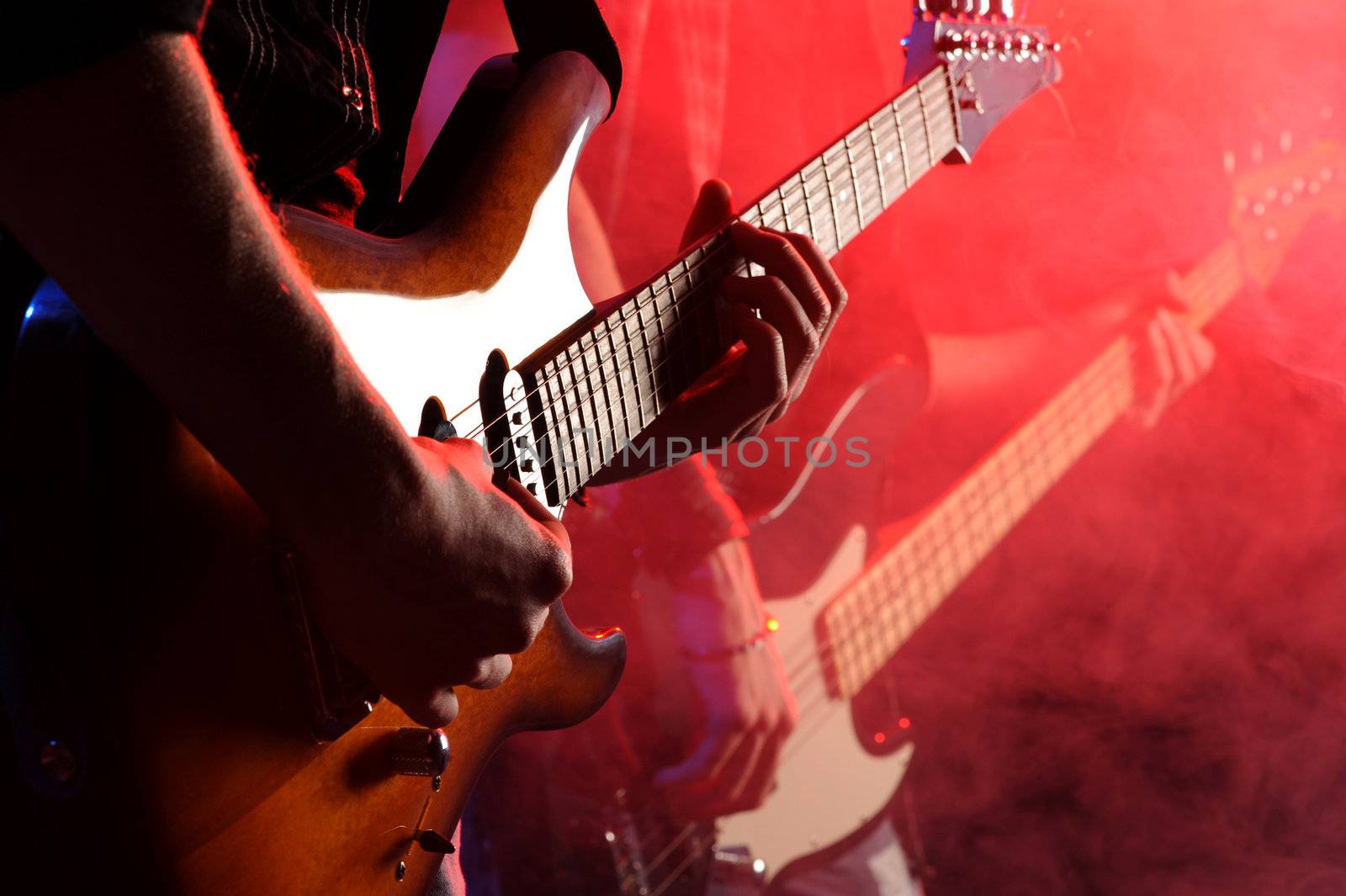 rock musicians playing at a live concert by stokkete