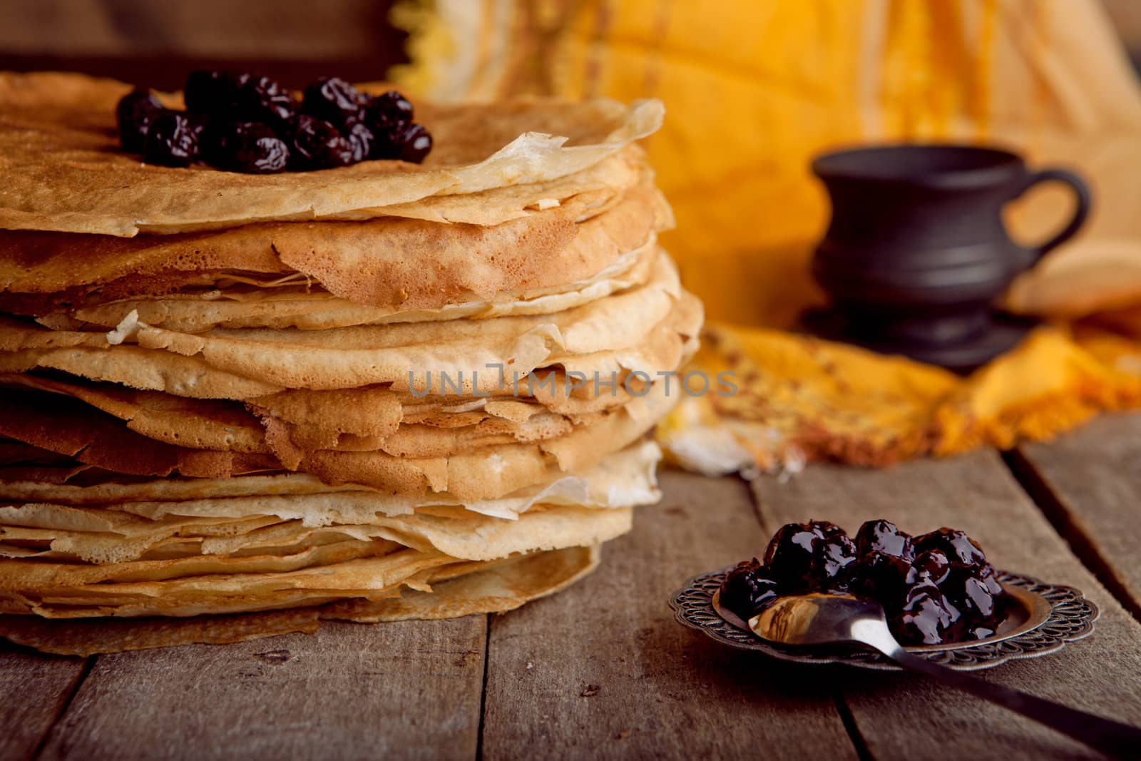 Crepes on the wooden table with cherry