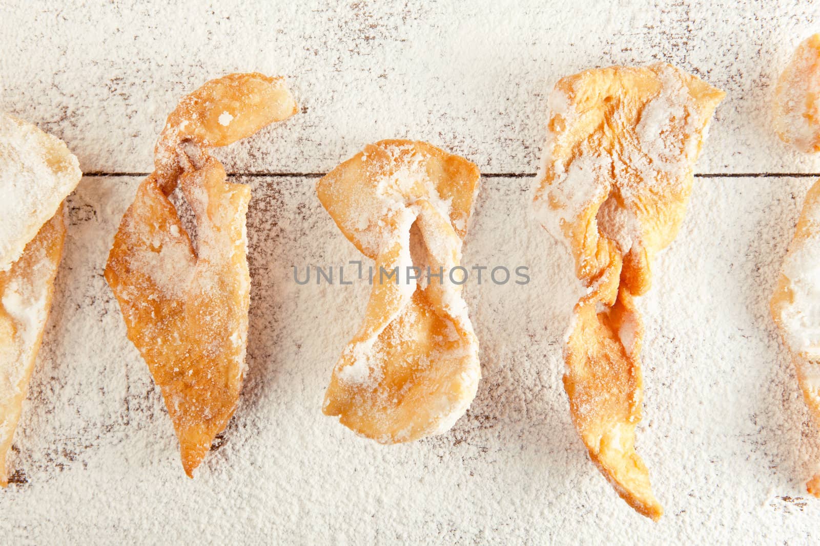 Sugar-coated strips of dough fried in oil  on the wooden table