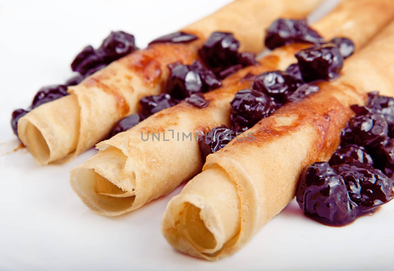 Crepes on white platee with cherry