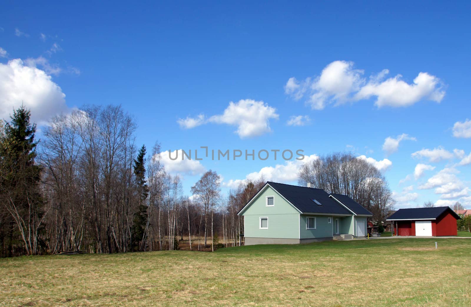 Landscape with the modern house on a background of the blue sky