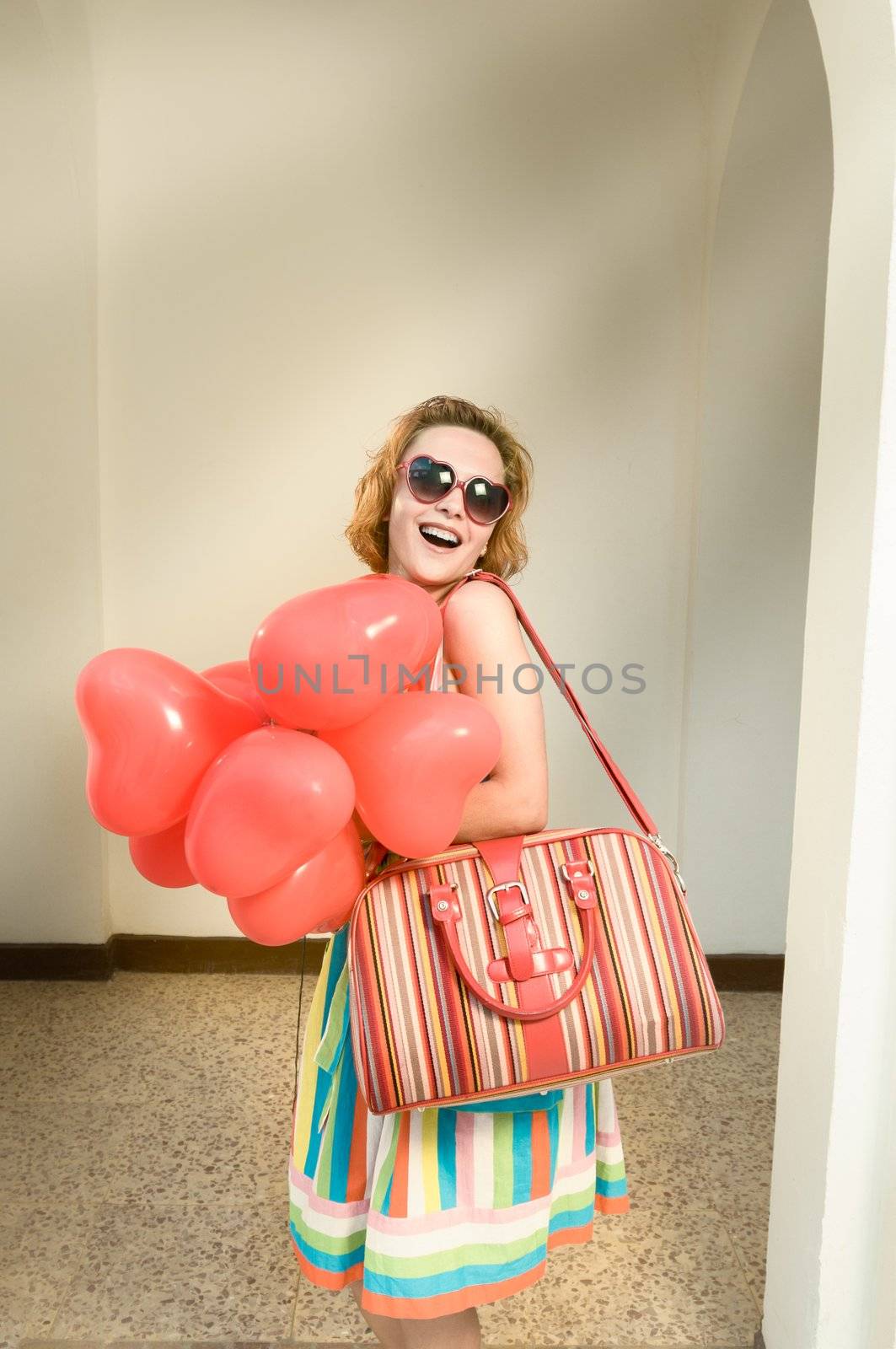 Beautiful red woman with lots of heart shaped baloons