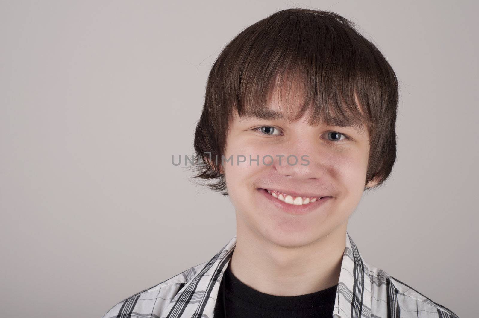 portrait of teen boy, gray background gray