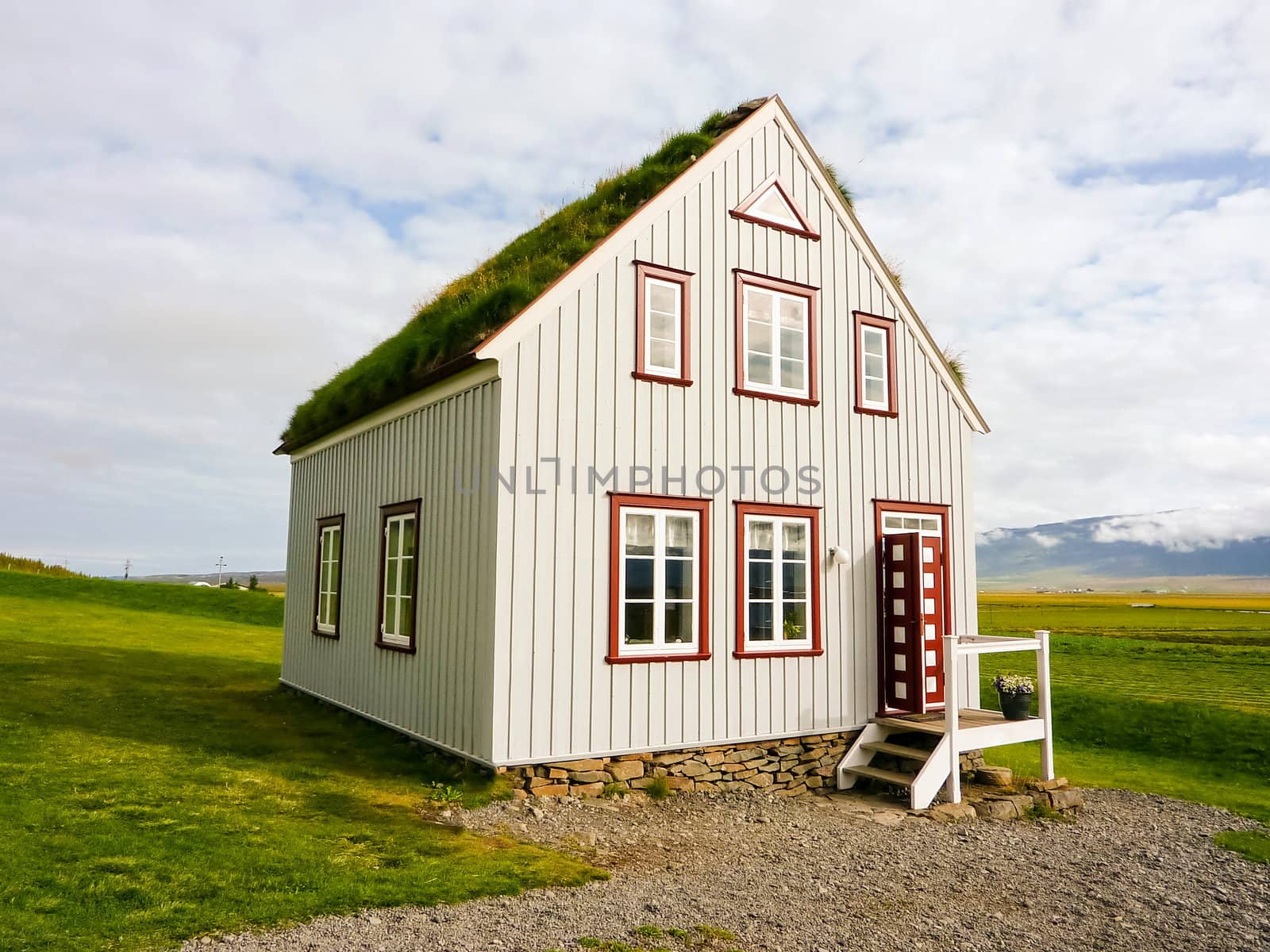 Icelandic traditional alone turf roof house in countryside