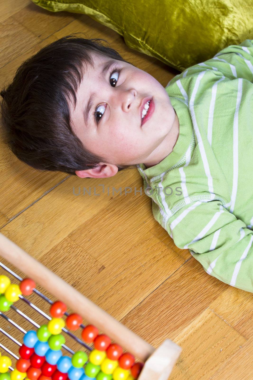Happy little boy playing with colorful abacus, studio shot