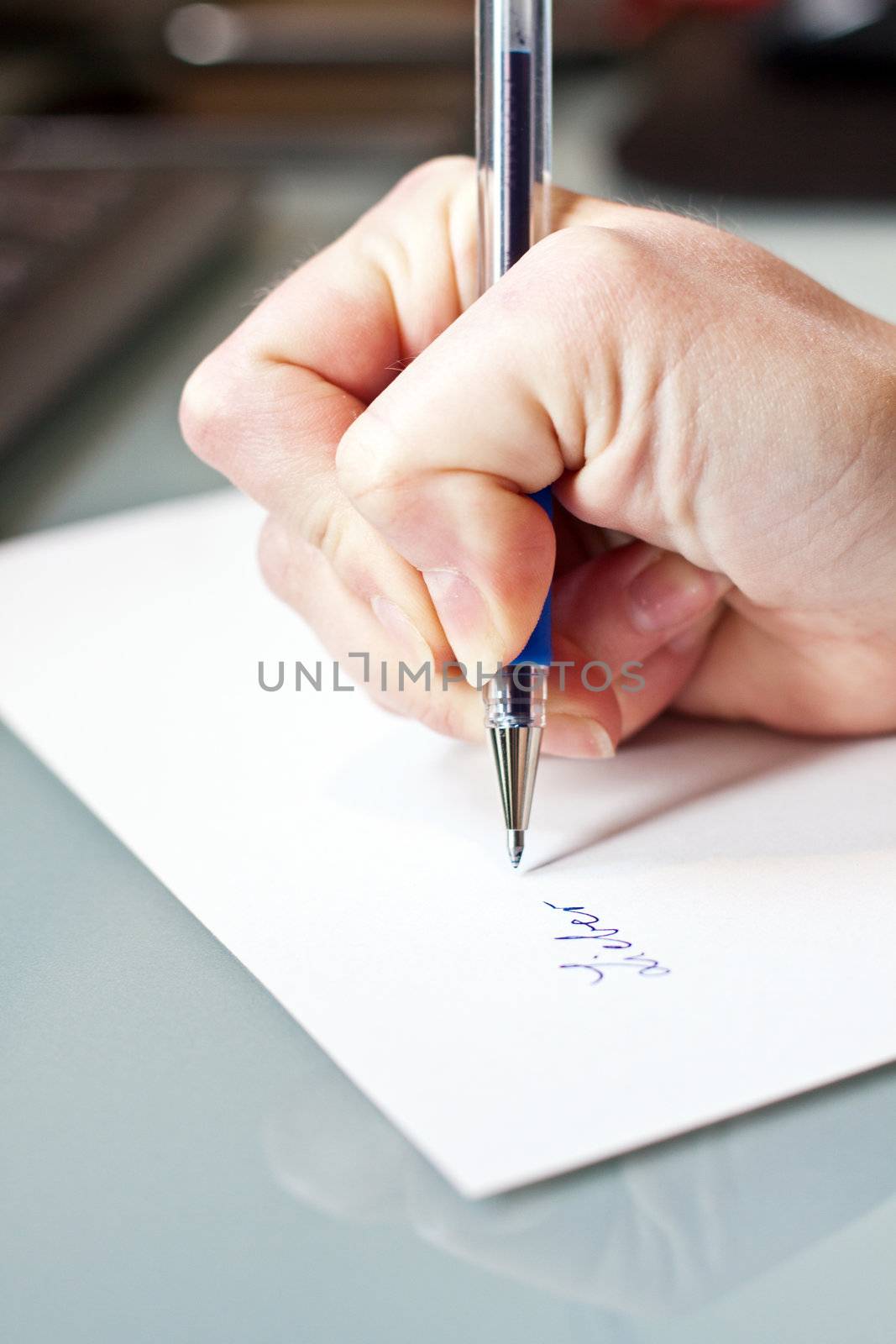 womans hand is writing a letter with a pen 