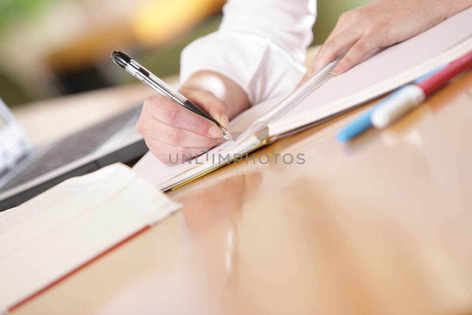 young woman hands are writing by stokkete