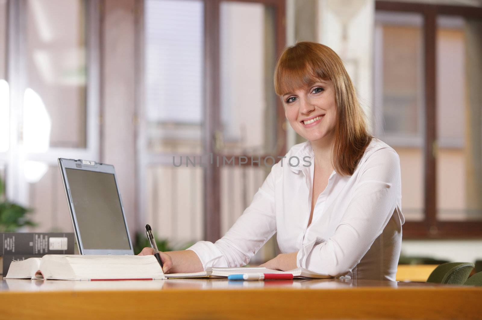 Portrait of a smiling caucasian teen girl studying at home 