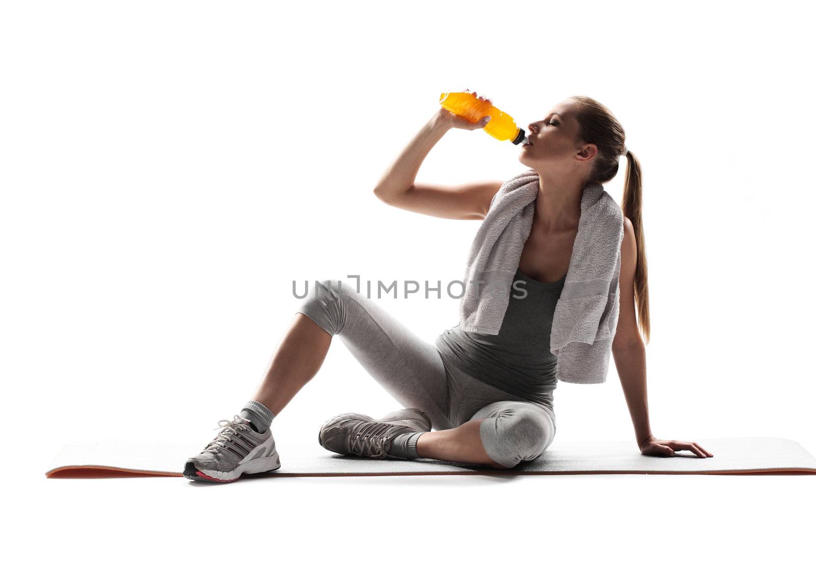 Thirsty young woman drinking after fitness workout. 
