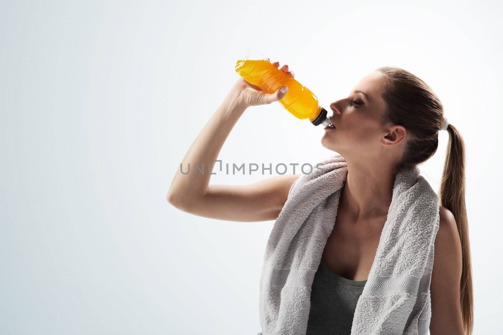 Thirsty young woman drinking after fitness workout

