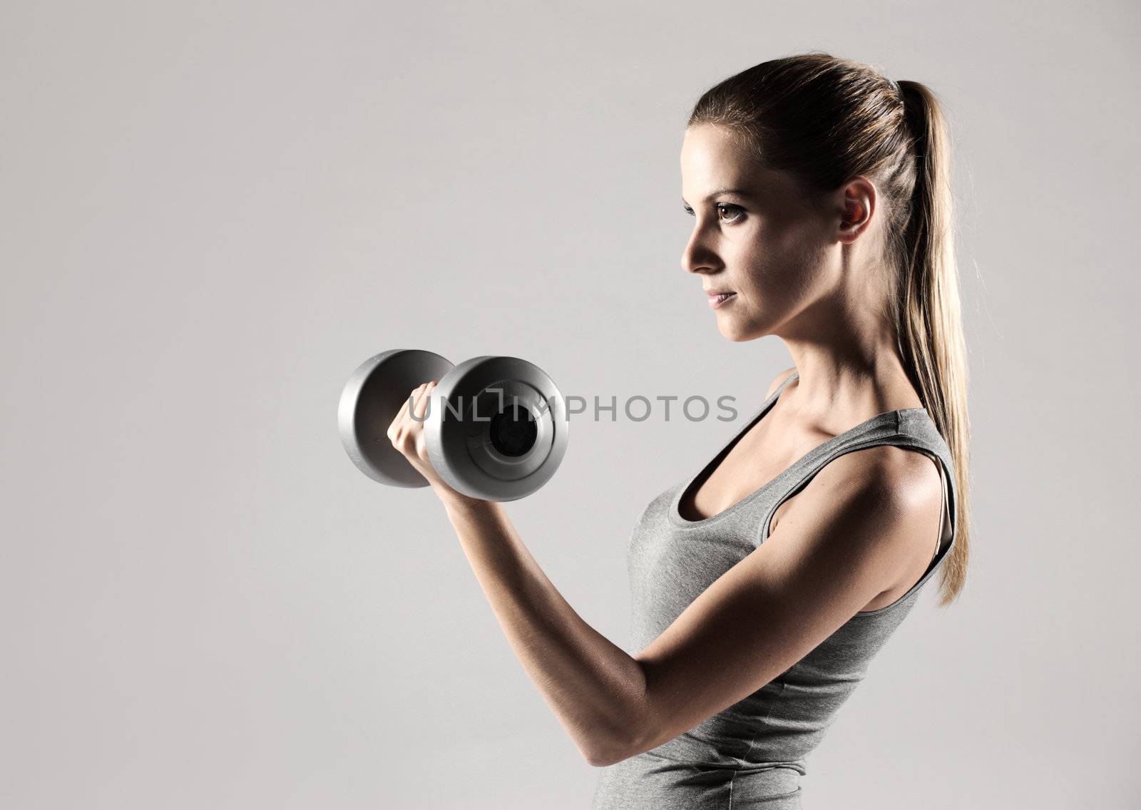 Woman lifting weights by stokkete