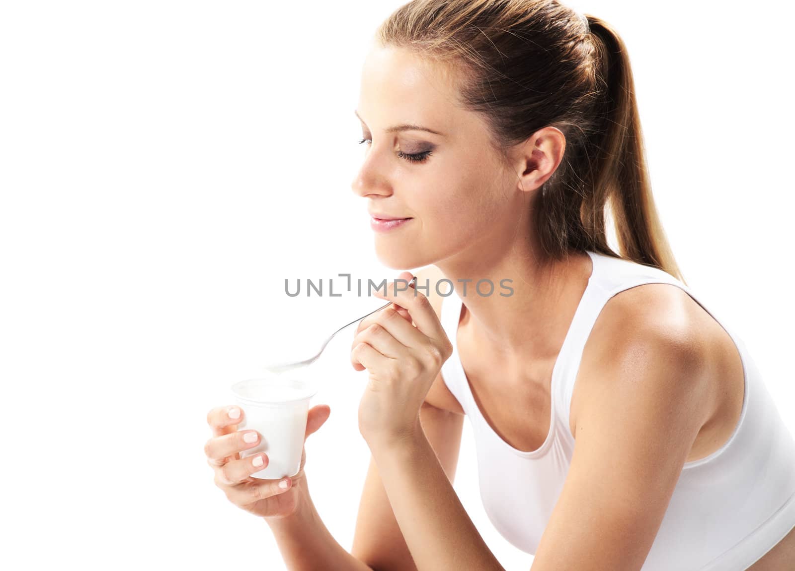 Young woman eating yogurt as breakfast or snack
