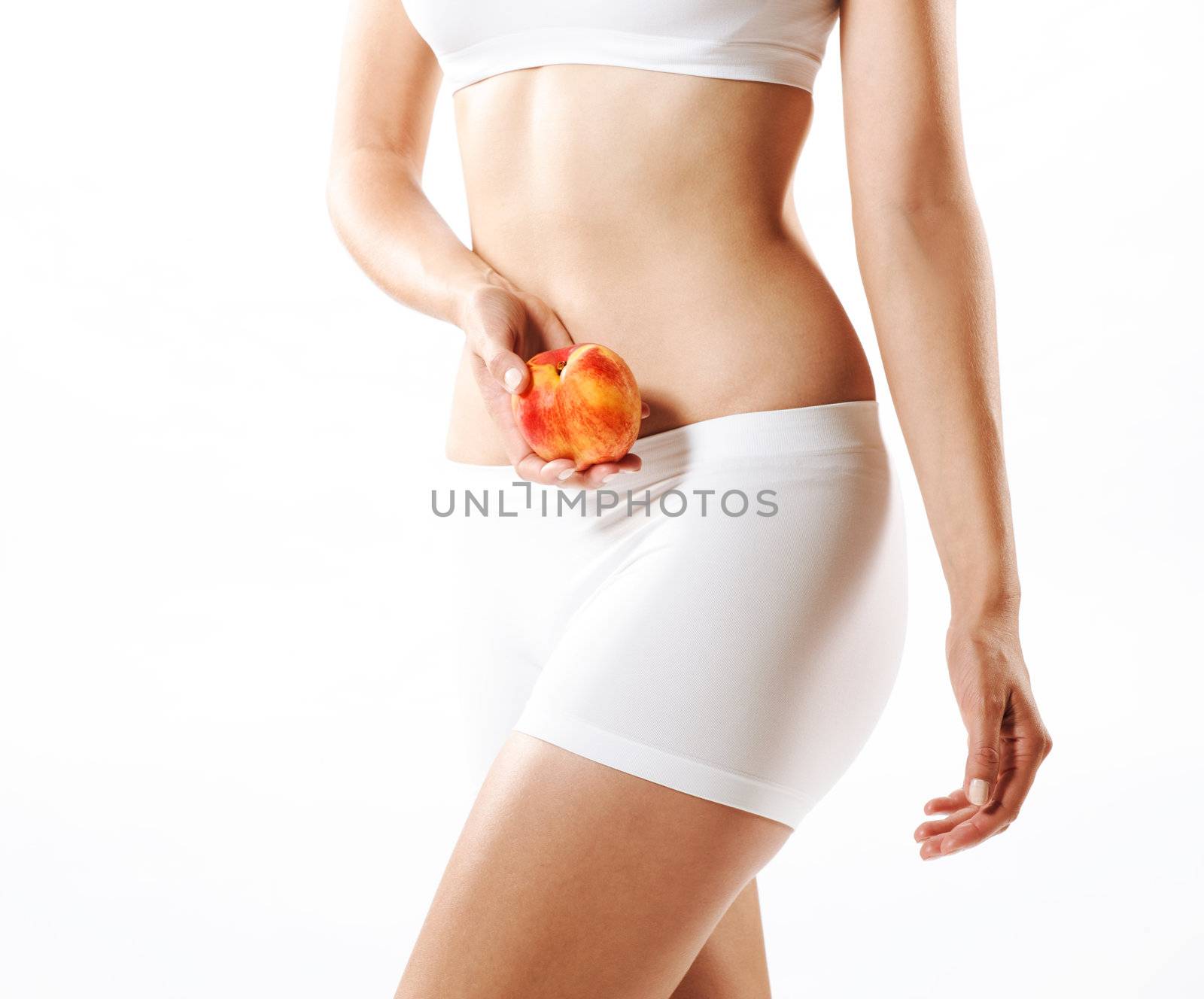 Fit young woman holding a peach, shot on white