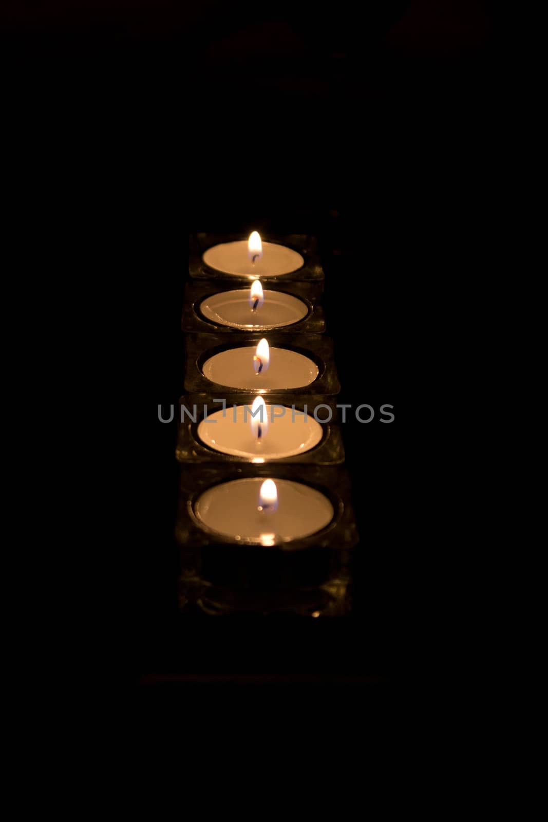 Tea light candles isolated on black.