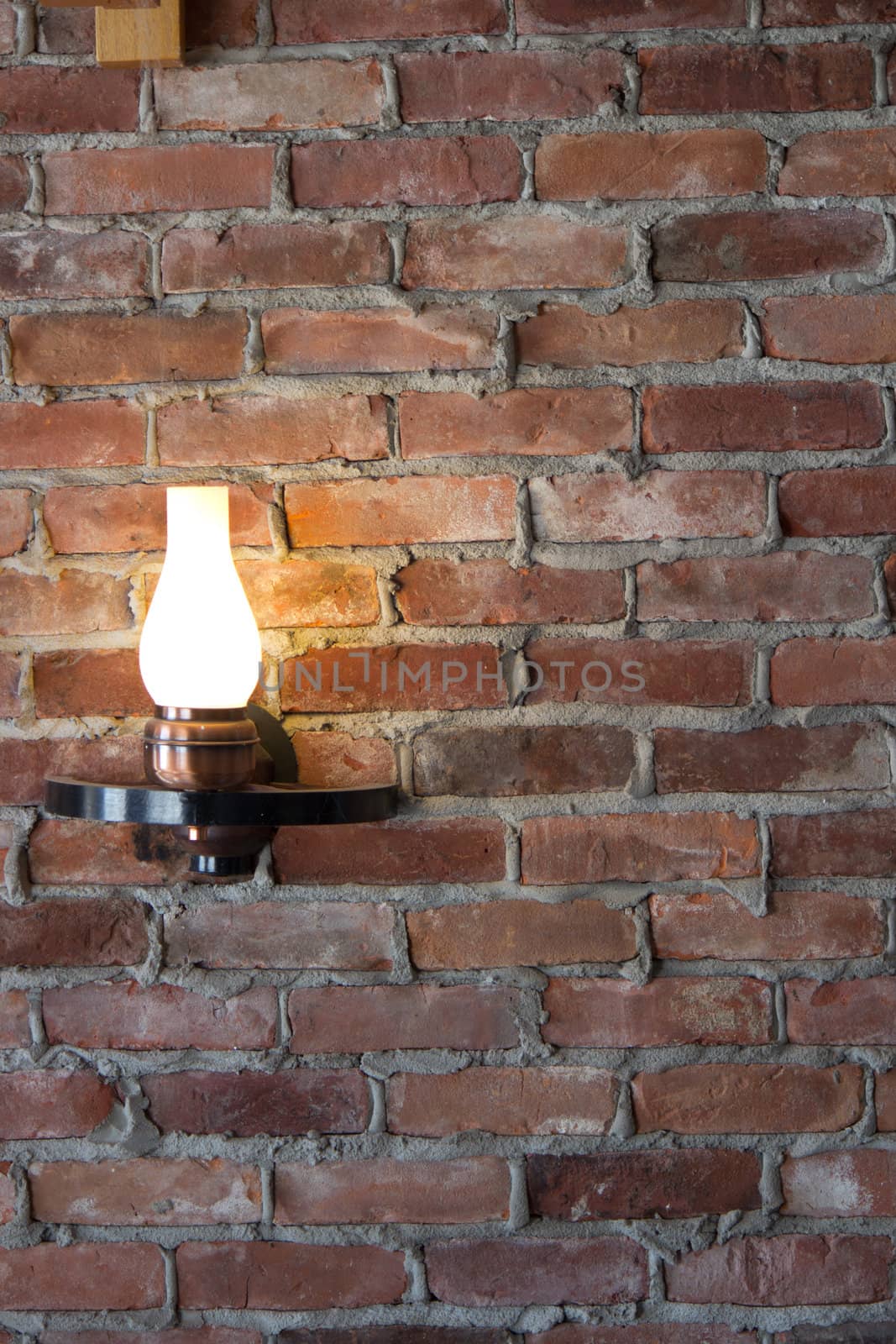 Old-fashioned sconce light on a brick wall.