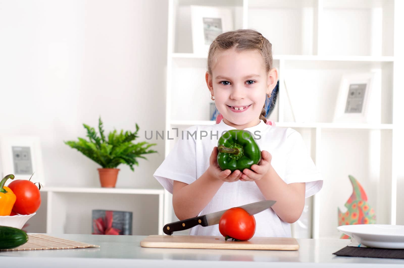 beautiful girl in the kitchen cooking vegetables