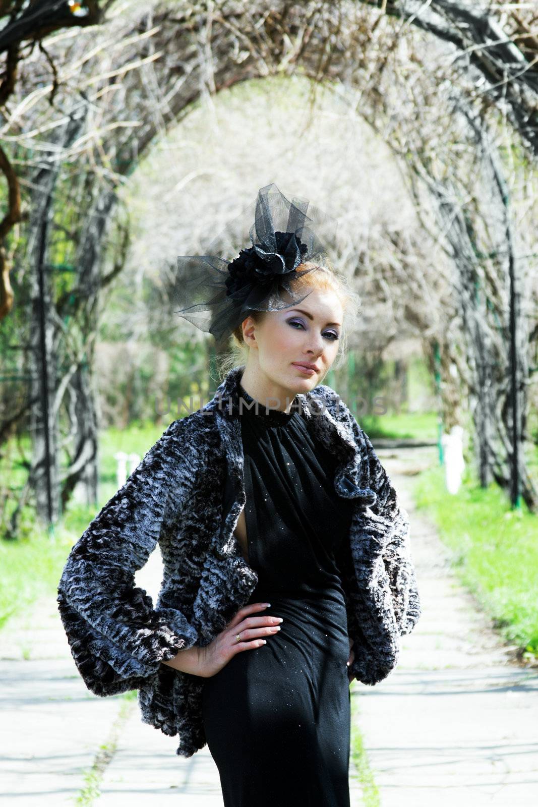 Retro-styled woman standing under arch outdoor