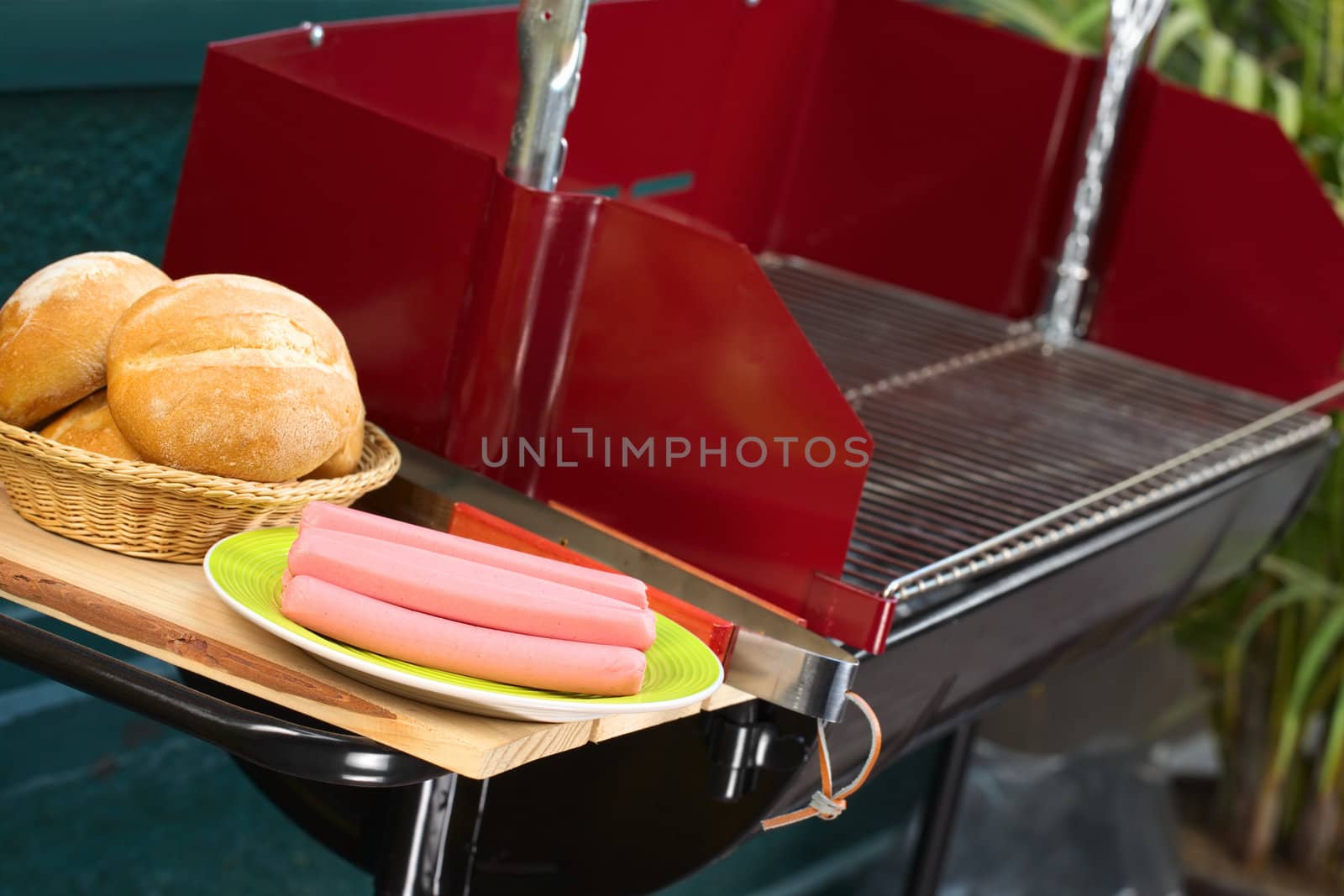 Preparing a barbecue with sausages and buns (Selective Focus, Focus on the sausages)