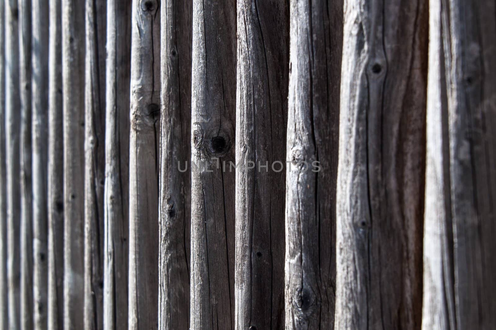 the colour and texture of a part of a weathered wooden fence.