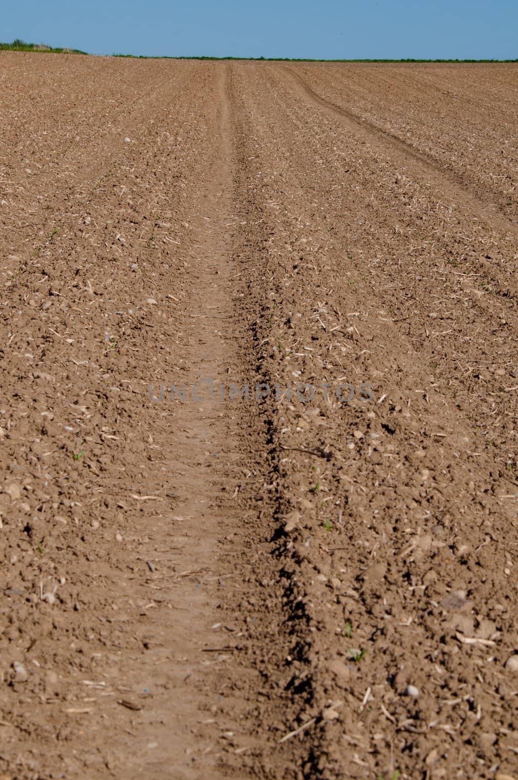 Closeup on ploughed field with horizon in early spring