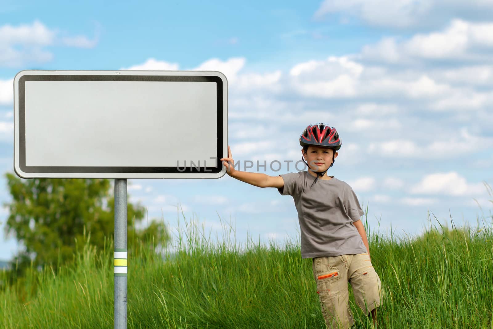 Boy cyclist leaning on blank sign by artush