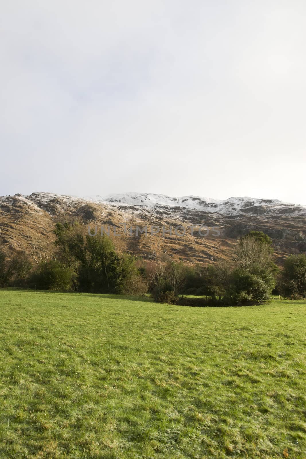 rocky mountain and fields countryside snow scene in irish speaking area of county Kerry Ireland with copyspace