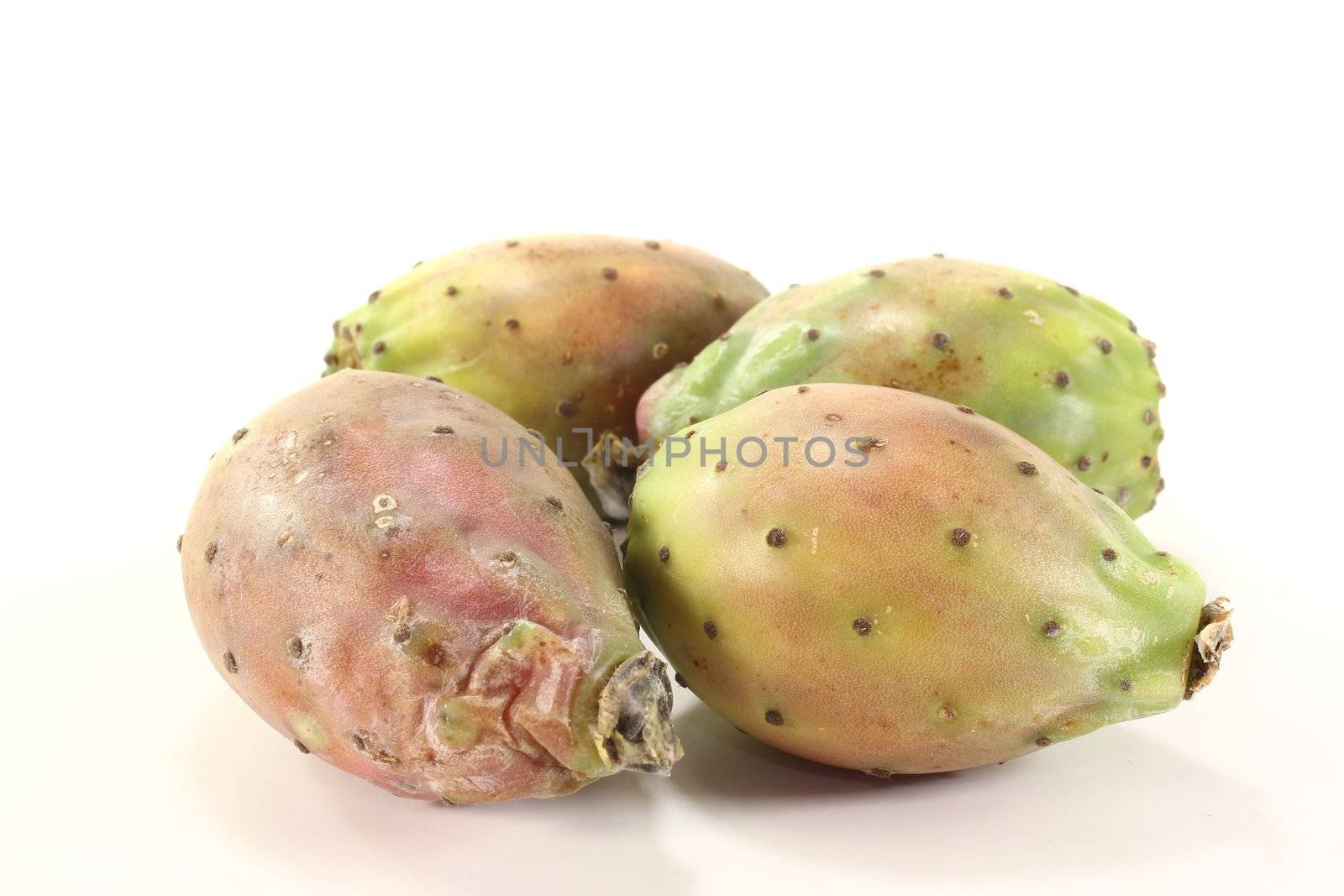 four fresh red and green prickly pears on a bright background