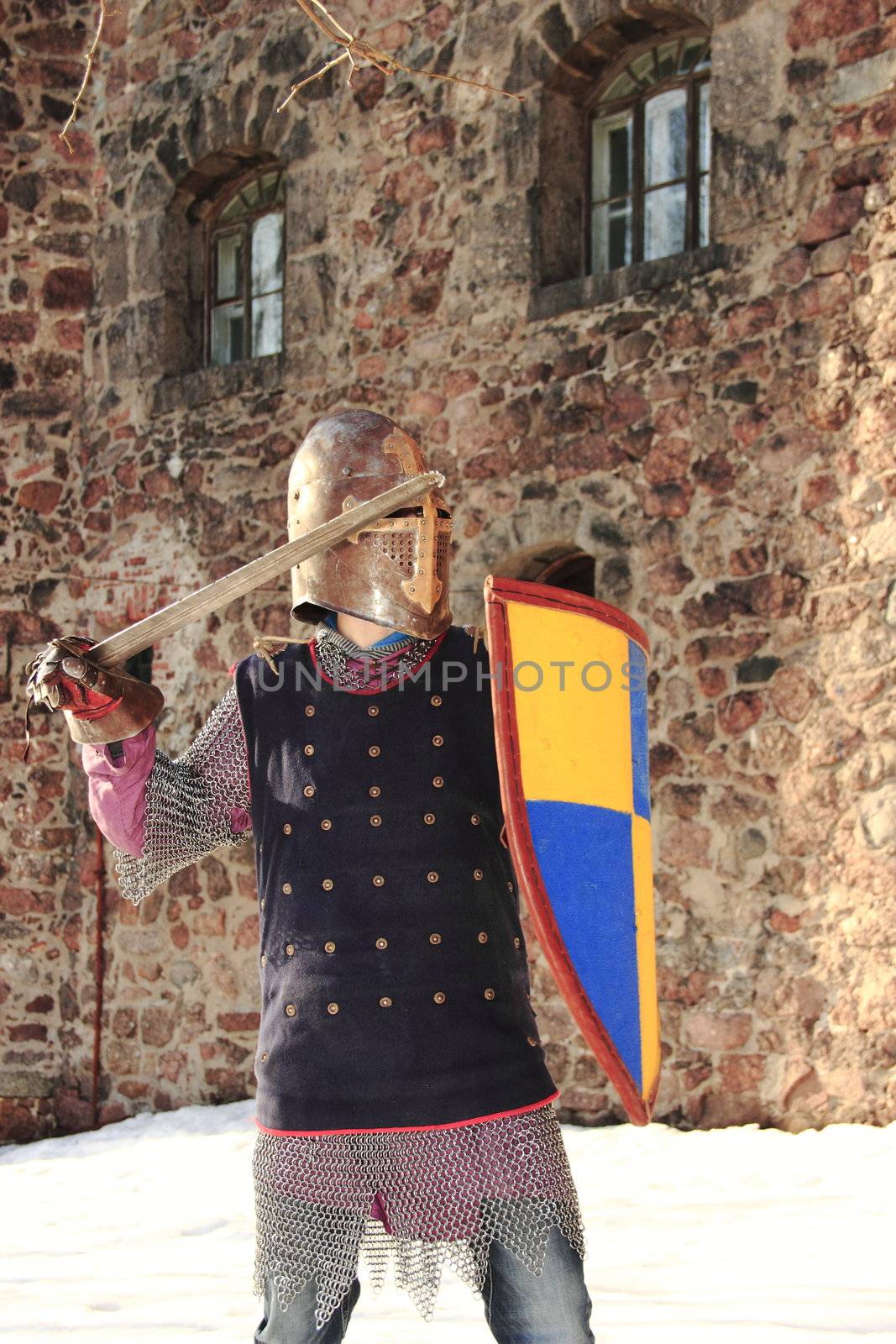 warlike knight in armor against the fortress wall