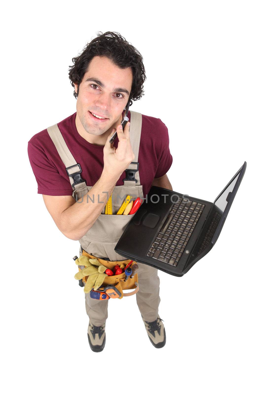 Laborer in dungarees with mobile phone and computer