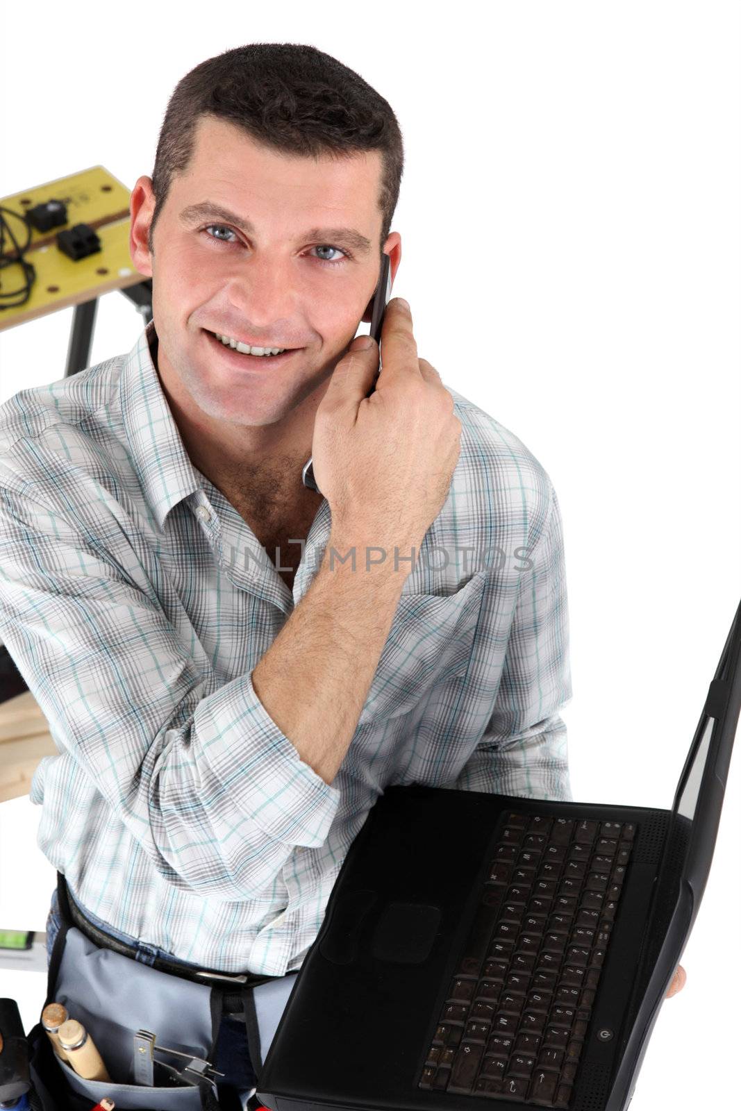 Handyman with a laptop and telephone