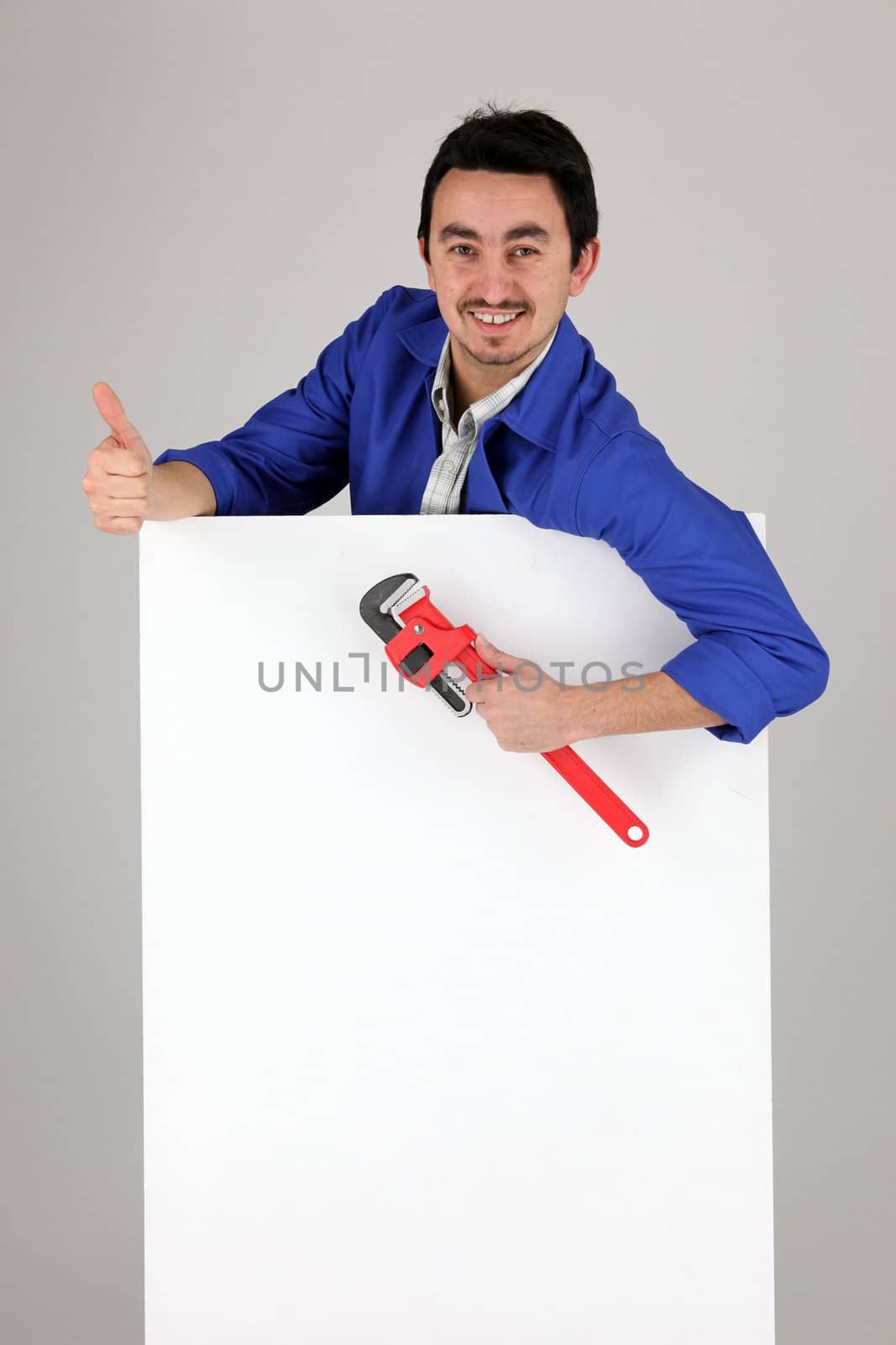 Man with a monkey wrench and a blank poster