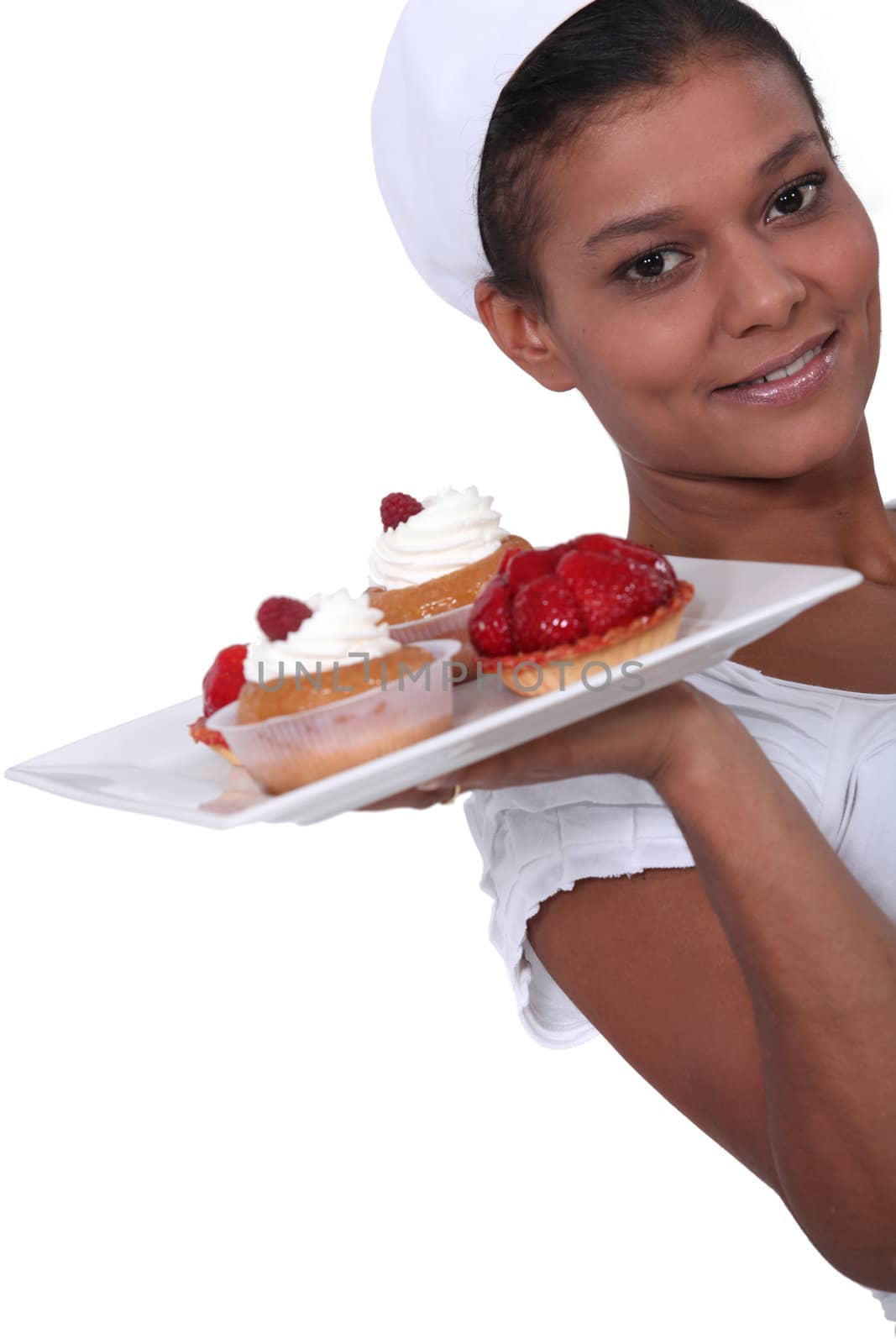 Woman holding plate of fruit tarts