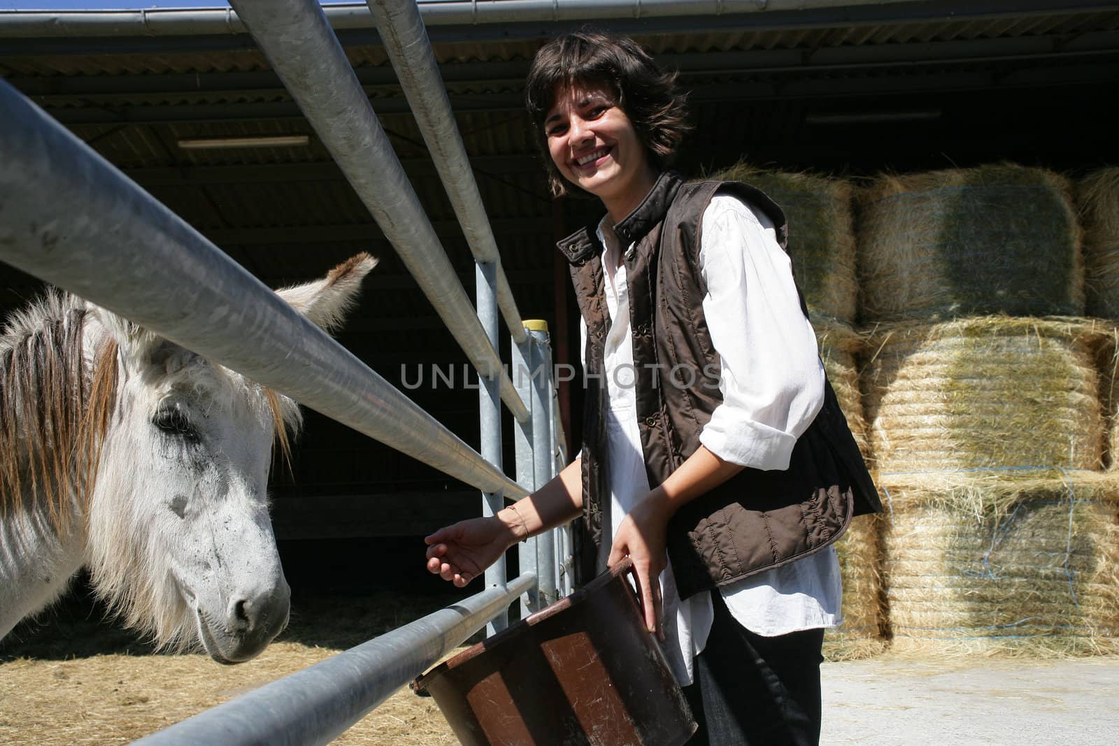 Female farmer stood by horse enclosure