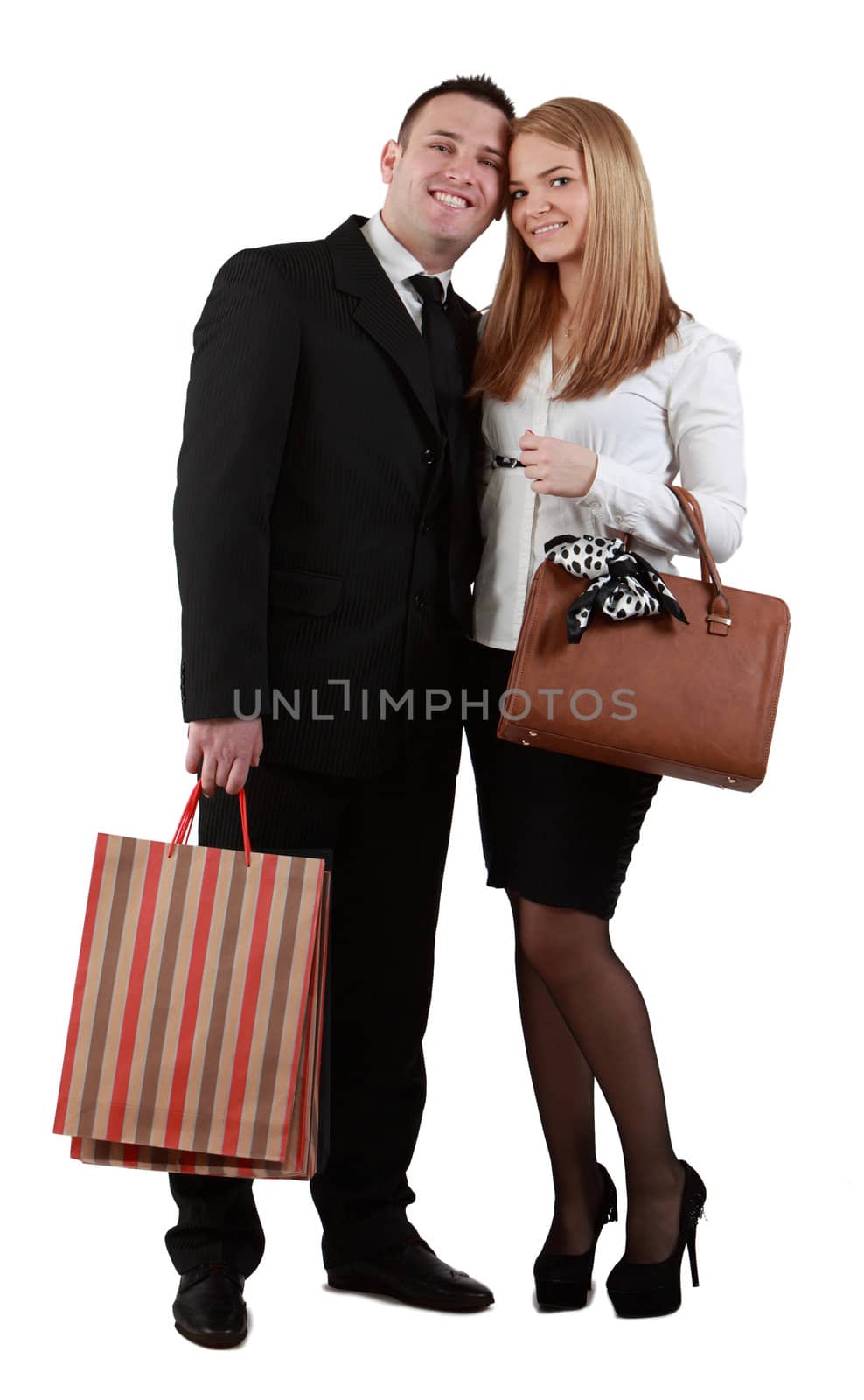 Happy young couple with shopping bags posing in a studio against a white background.